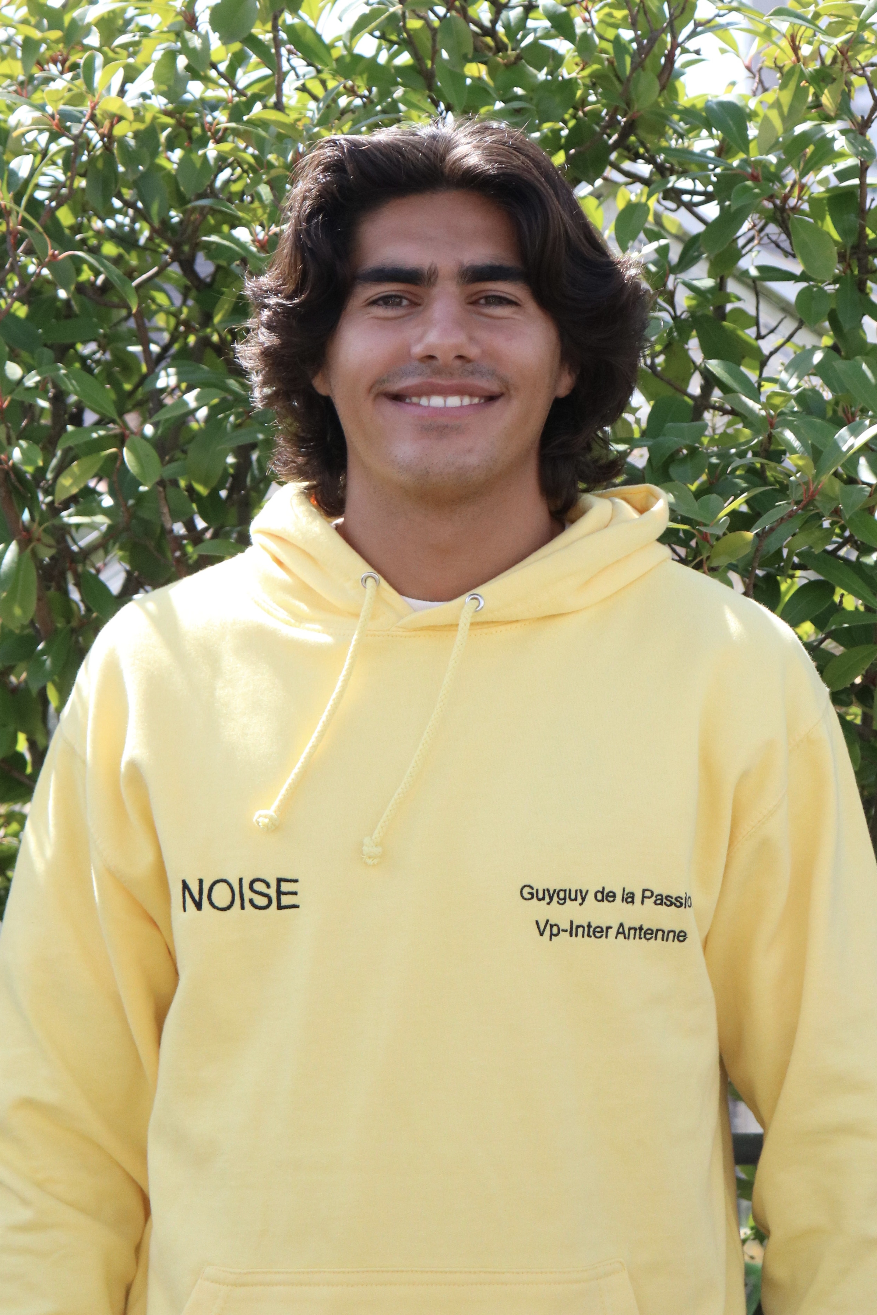 Guy-Alexandre smiling in a yellow sweatshirt